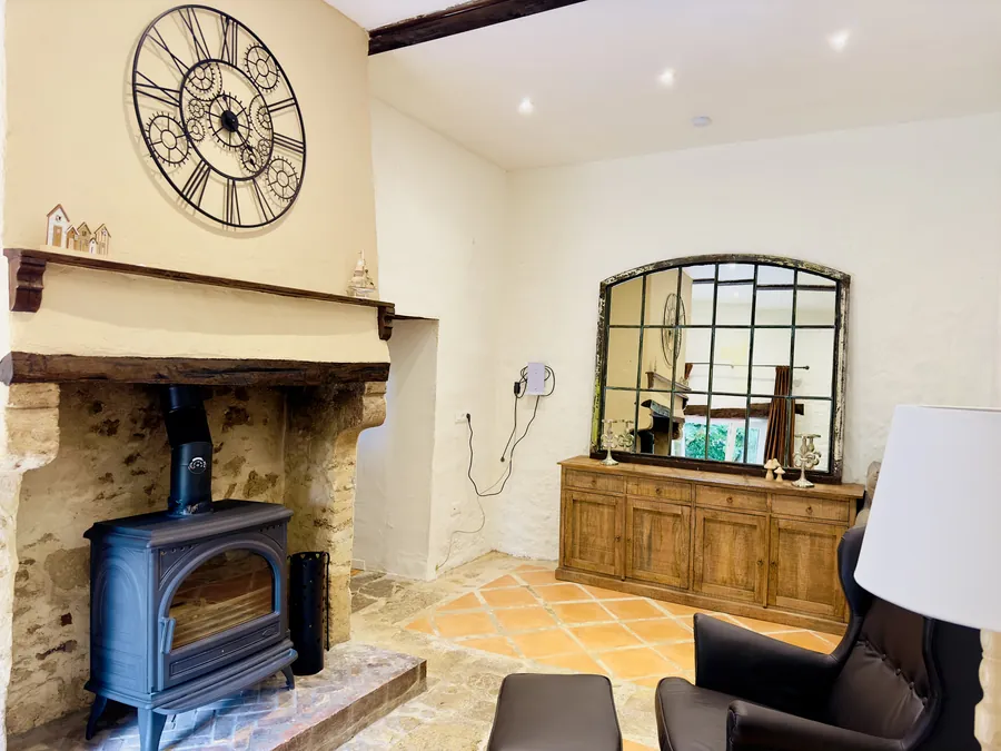 Sitzplatz vor dem offenen Kamin mit Sideboard und großem Spiegel