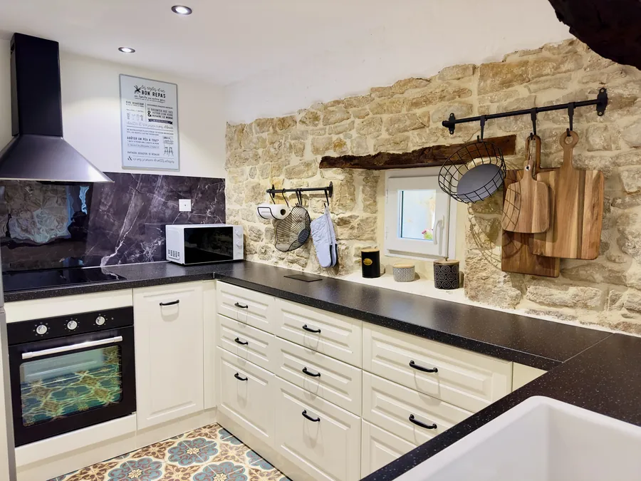 Küche von La Benoîterie mit Natursteinwand und Backofen