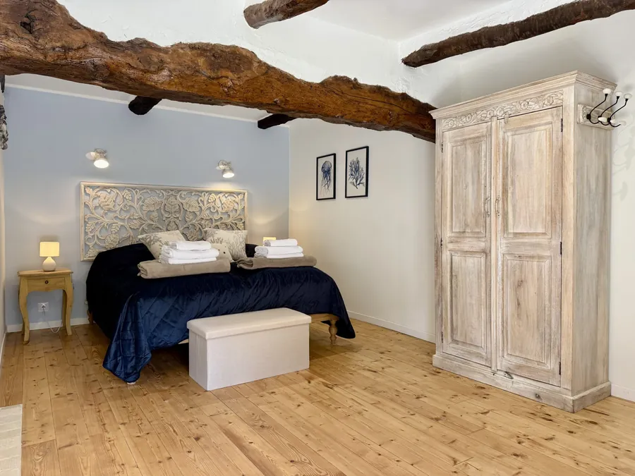 Schlafzimmer im Erdgeschoss mit Schrank und alten Deckenbalken