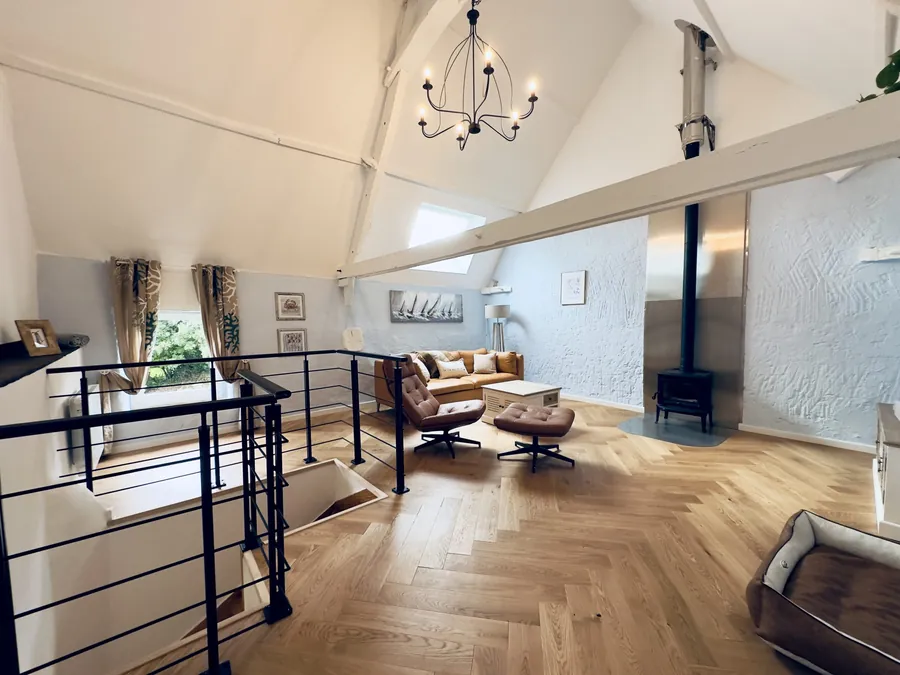 Kamin, Ledersofa und Ohrensessel im Wohnzimmer von La Benoîterie