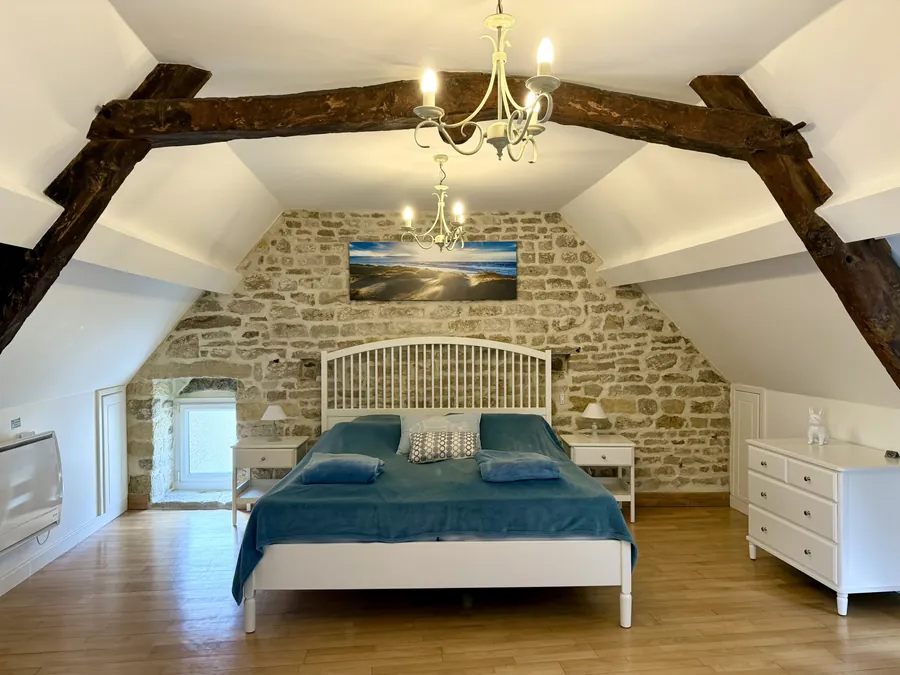 Doppelbett im oberen Schlafzimmer unter alten Deckenbalken